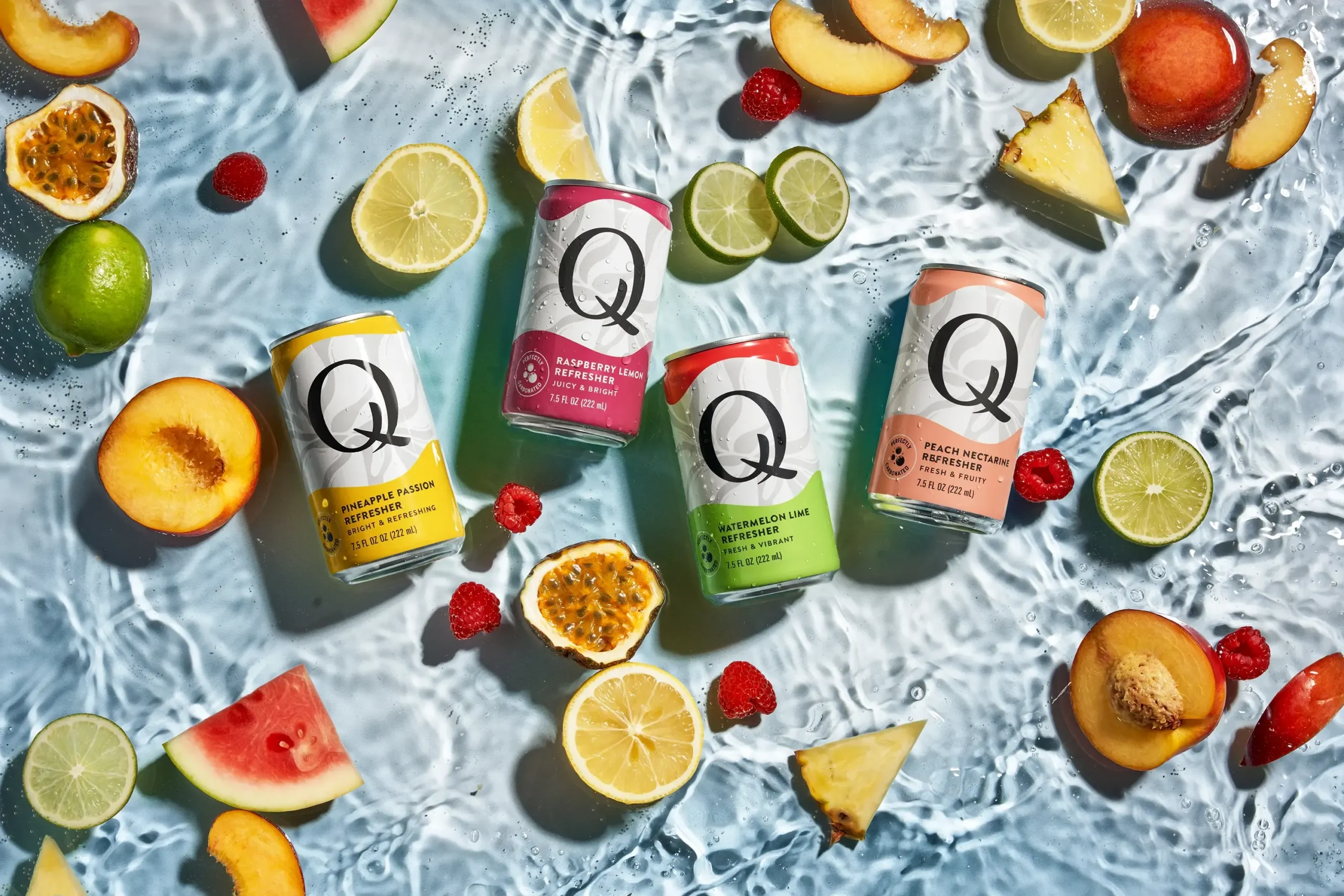 Colorful Q Mixers cans arranged with fresh fruit