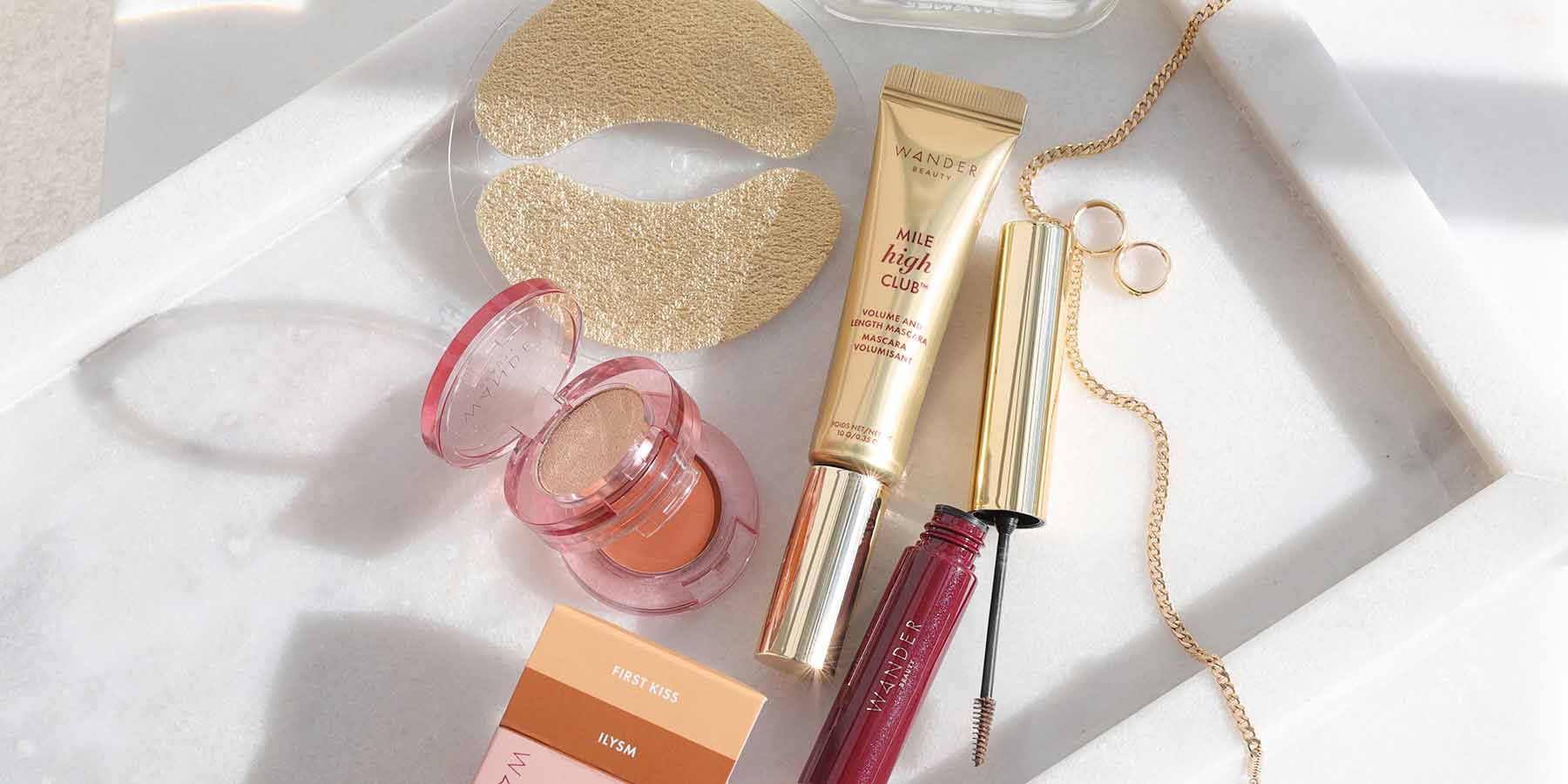 Wander Beauty cosmetics arranged on white satin